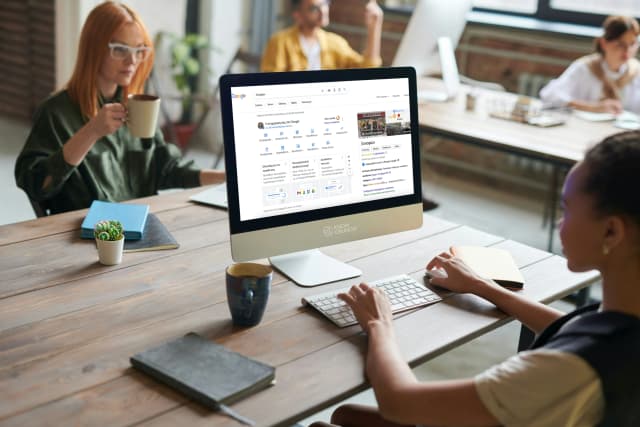 Team working on Google business profile optimization at a shared desk.